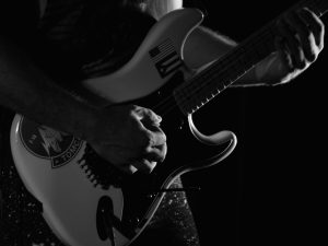 Donated photo from Evan Omana of a guitar player strumming his instrument with passion.