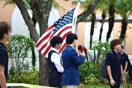 Students pass by these two seniors as they shout the Constitution with an American flag in hand. Picture by: <a href="https://ppchsnews.com/staff_profile/evan-omana/">Evan Omana</a>
