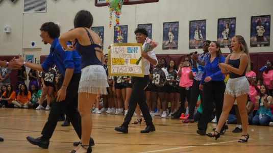 Shortly after the Latin Dance team performs, a PPCHS couple surprises the crowd with a heartwarming Homecoming proposal, complete with a handmade sign and flowers.