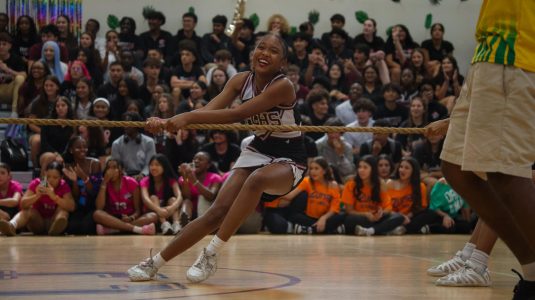 A PPCHS cheerleader competes in a game of tug-of-war, laughing as she enjoys the Pep Rally's atmosphere.