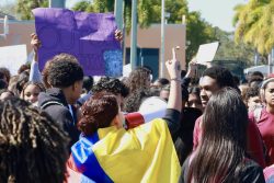 Students walk to the field, holding up signs for helicopters to see.