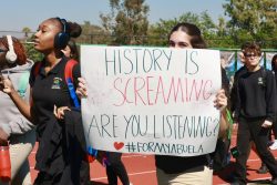 Senior Gabriana Bravo holds her sign in honor of her Abuela.