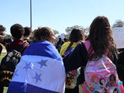 One student wraps the Honduran flag around her shoulders.