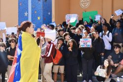 Senior Mariana Rios leads protesters on the River of Grass Auditorium steps with a megaphone.